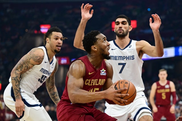 Feb 23, 2025; Cleveland, Ohio, USA; Cleveland Cavaliers guard Donovan Mitchell (45) drives to the basket against Memphis Grizzlies forward Santi Aldama (7) during the first half at Rocket Arena. Mandatory Credit: Ken Blaze-Imagn Images