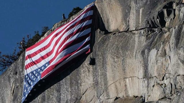 National park employees hoist an American flag upside-down on Yosemite National Park's summit El Capitan on Saturday. 