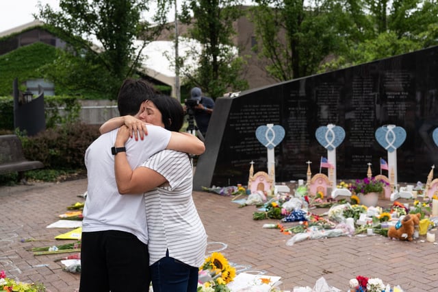Lori Weisskopf of Highland Park embraces her son Jeremy at a makeshift memorial for victims of the July 4th mass shooting in downtown Highland Park, Illinois, on July 6, 2022.