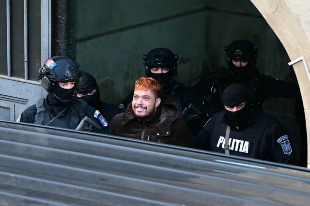 Le sourire provocateur de Mohamed Amra lors de son arrivée au tribunal de Bucarest