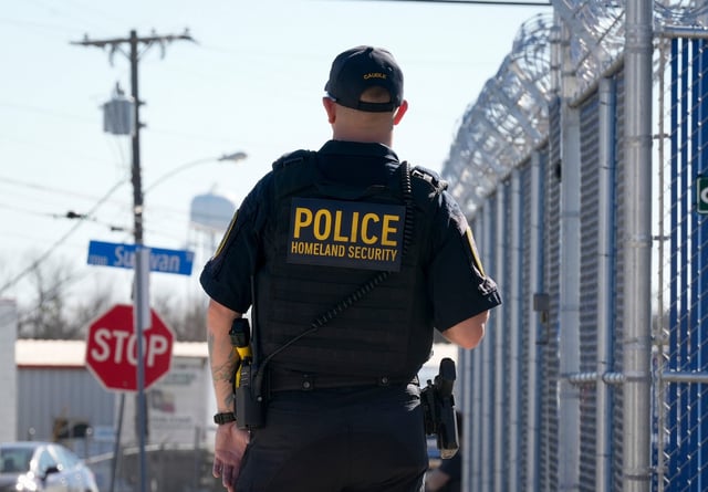 Department of Homeland Security Inspector Marshall Caudle, watches a protest at a new Immigration and Customs Enforcement facility in Pflugerville on Feb. 1, 2025.
