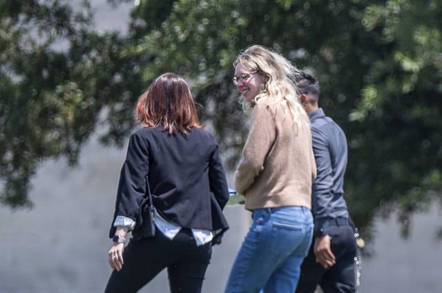 Elizabeth Holmes, founder of the failed blood testing start-up Theranos, center, is escorted by prison officials into the federal prison camp in Bryan, Texas, on May 30, 2023. 