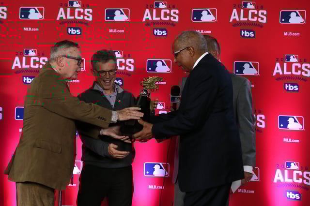 Owner Larry Dolan of the Cleveland Indians is handed the William Harridge Trophy after defeating the Toronto Blue Jays in game five to win the American League Championship Series at Rogers Centre on October 19, 2016 in Toronto, Canada.