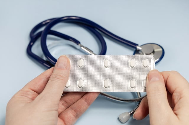 A doctor holds a pack of antidepressants.