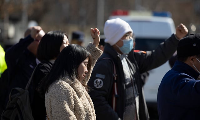Les proches des passagers du vol MH370 de Malaysia Airlines qui a disparu le 8 mars 2014, scandent des slogans alors qu'ils se rassemblent près de l'ambassade de Malaisie à Pékin, en Chine, le 8 mars 2024.