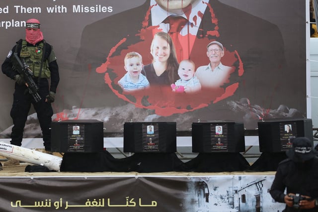 A Hamas militant stands next to coffins as they are handed to the Red Cross in Khan Younis, Gaza, on February 20.