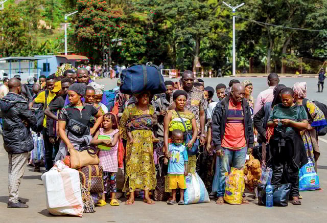 Congolese civilians who fled from Bukavu, eastern Democratic Republic of Congo following clashes between M23 rebels and the Armed Forces of the Democratic Republic of the Congo (FARDC), carry their belongings as they gather at the Rusizi border crossing point to return home, in Rusizi district, Rwanda, February 17, 2025. REUTERS/Stringer/File Photo