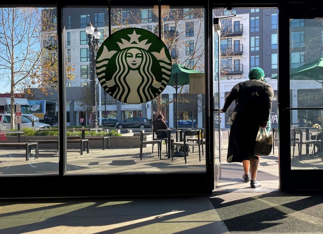 A costumer exits a Starbucks store in Oakland, Calif., Jan. 16, 2025. Starbucks has announced staff layoffs and that some drinks are leaving the menu March 4. 