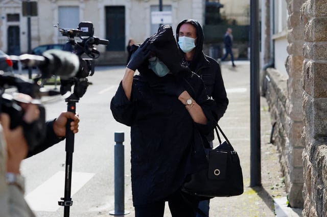 A woman believed to be Marie-France, ex-wife of ex-surgeon Joel Le Scouarnec, walks to attend the trial of Scouarnec, charged with aggravated rape and sexual assault against hundreds of children over several decades, in Vannes, Brittany, France, February 25, 2025. REUTERS/Stephane Mahe