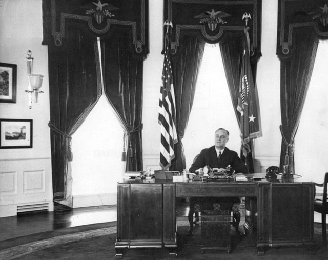 President Franklin D. Roosevelt is seated at the Hoover desk in the Oval Office in 1935.