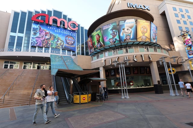 People walk by an AMC theatre in Burbank, California, U.S., October 12, 2023. REUTERS/Mario Anzuoni/File Photo