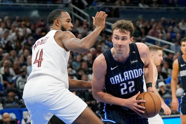 Orlando Magic forward Franz Wagner (22) makes a move to get around Cleveland Cavaliers forward Evan Mobley (4) during the first half of an NBA basketball game, Tuesday, Feb. 25, 2025, in Orlando, Fla. (AP Photo/John Raoux)