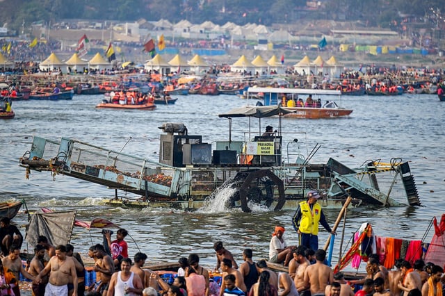 A worker collects waste using a trash skimmer machine across the Triveni Sangam, as pilgrims gather to take a holy dip in Prayagraj on Tuesday, February 25.