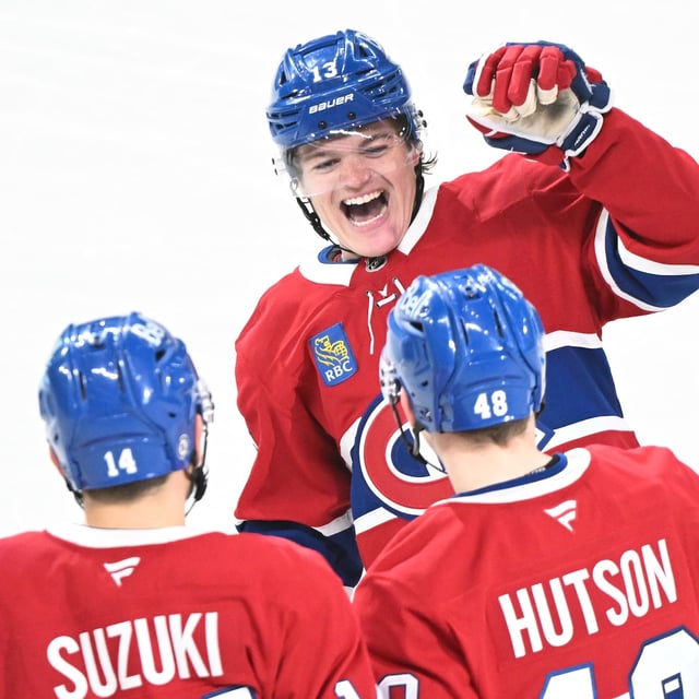 Montreal Canadiens' Lane Hutson (48) celebrates with teammates Nick Suzuki (14) and Cole Caufield (13) after scoring against the Carolina Hurricanes during third period NHL hockey action in Montreal, Tuesday, February 25, 2025. THE CANADIAN PRESS/Graham Hughes