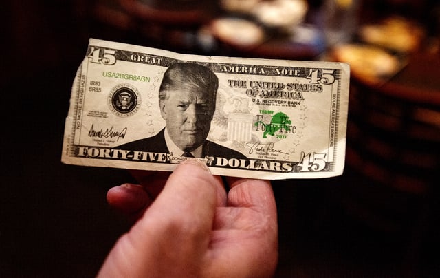 Al Deno, of Mountain Top, Pa., holds up a $45 bill with President Donald Trump&#39;s face on it before watching the president announce his bid for re-election during a Republican gathering at the Tipsy Turtle in Dupont, Pa. on Tuesday, June 18, 2019.