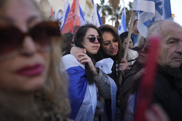 Mourners react as the convoy carrying the coffins of slain hostages Shiri Bibas and her two children, Ariel and Kfir, passes by during their funeral procession in Rishon Lezion, Israel, Wednesday, February 26, 2025. The mother and her two children were abducted by Hamas on October 7, 2023, and their remains were returned from Gaza to Israel last week as part of a ceasefire agreement with Hamas.