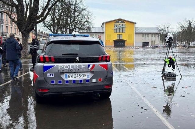 Une voiture de police est vue devant le marché Marche du Canal Couvert, après une attaque au couteau mortelle la veille, à Mulhouse, dans l’est de la France, le 23 février 2025.