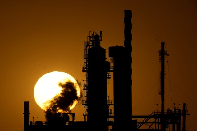 FILE - The CHS oil refinery is silhouetted against the setting sun Sept. 28, 2024, in McPherson, Kan. (AP Photo/Charlie Riedel, File)