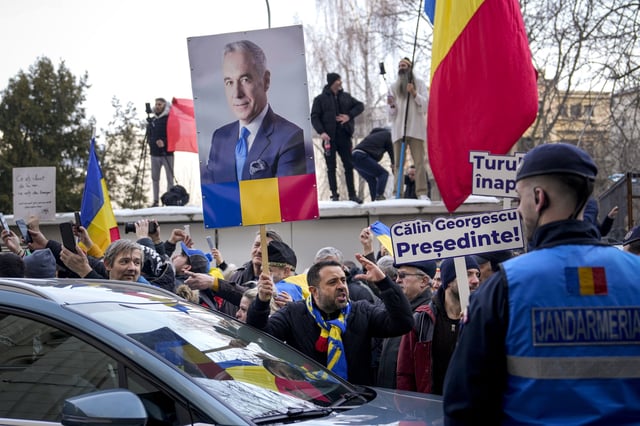 Romanian people holding up signs and protesting presidential candidate Calin Georgescu&#39;s detainment by authorities outside the General Prosecutor&#39;s Office, in Bucharest, Romania, on February 26, 2025.