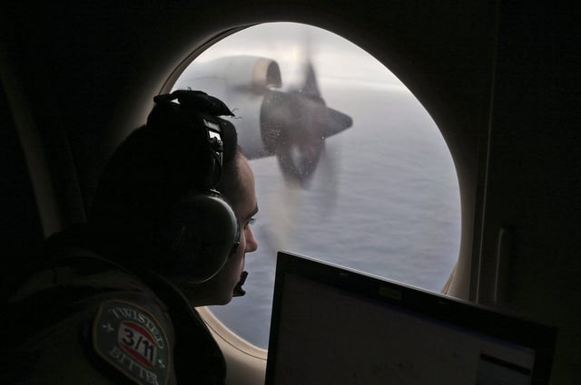 In this March 22, 2014 file photo, flight officer Rayan Gharazeddine scans the water in the southern Indian Ocean off Australia from a Royal Australian Air Force AP-3C Orion during a search for the missing Malaysia Airlines Flight MH370.