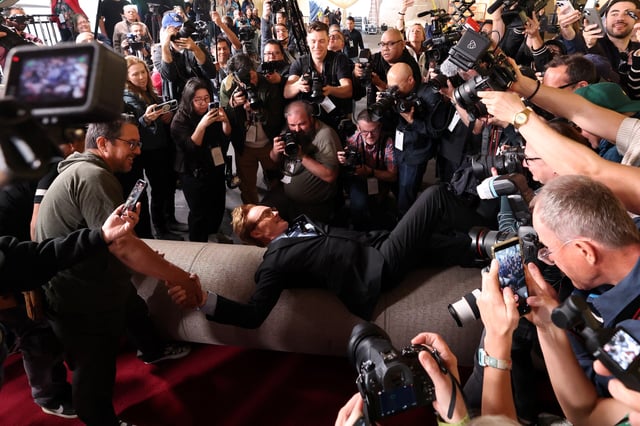 Academy Awards host Conan O'Brien lies over the red carpet during the rollout of the red carpet for the 97th Academy Awards in Los Angeles, California, U.S., February 26, 2025. REUTERS/Mario Anzuoni