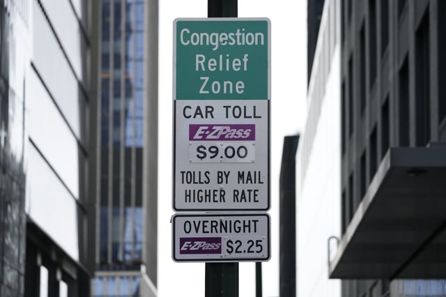 Signs advising drivers of congestion pricing tolls are displayed near the exit of the Lincoln Tunnel in New York, Wednesday, Feb. 19, 2025. (AP Photo/Seth Wenig)