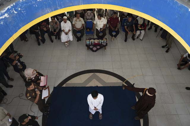 A Shariah Law official uses a rattan cane to whip one of two men convicted of gay sex in Banda Aceh, Aceh province, Indonesia, Thursday, Feb. 27, 2025.(AP Photo/Reza Saifullah)