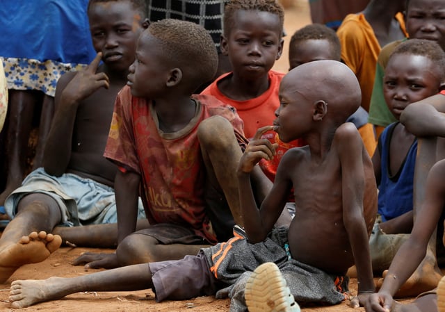 Orphans and children separated from their parents in Kadugli gather to eat boiled leaves for food at an IDP Camp within Sudan People's Liberation Movement-North (SPLM-N) controlled area in Boram County, Nuba Mountains, South Kordofan, Sudan June 22, 2024. REUTERS/Thomas Mukoya/File Photo