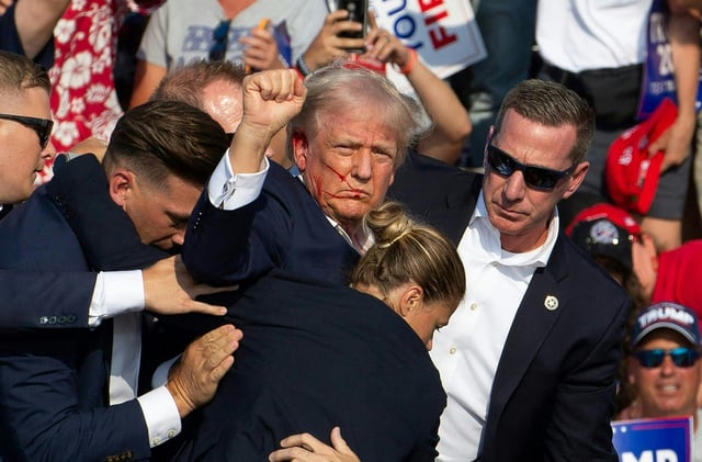 Donald Trump is seen with blood on his face surrounded by secret service agents as he is taken off the stage at a campaign event at Butler Farm Show Inc. in Butler, Pennsylvania, July 13, 2024.