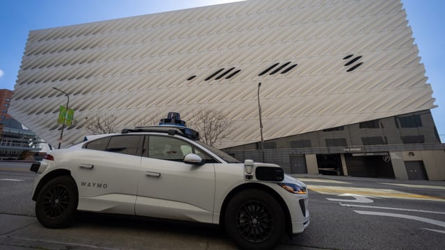 A Waymo robotaxi Jaguar I-PACEs driverless car parks next to The Broad in downtown Los Angeles Monday, March 11, 2024