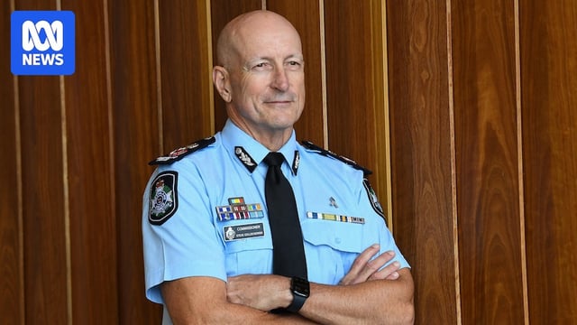 A man in a police uniform, with his arms crossed.