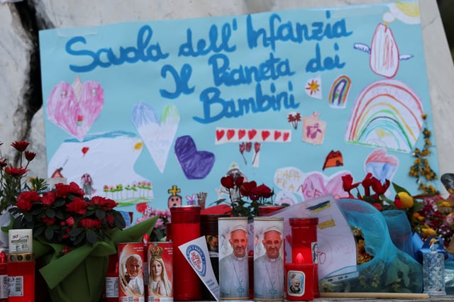 Des fleurs, des bougies et des images du pape François sont placées devant la statue du défunt pape Jean-Paul II devant l’hôpital Gemelli, où le pape François est admis pour traitement, à Rome, en Italie, le 28 février 2025.