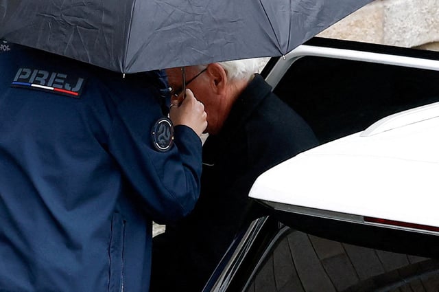 Prison officers escort ex-surgeon Joel Le Scouarnec from a vehicle, during his trial, where he is charged with aggravated rape and sexual assault against hundreds of children over several decades, in Vannes, Brittany, France, February 25, 2025. REUTERS/Stephane Mahe/File Photo