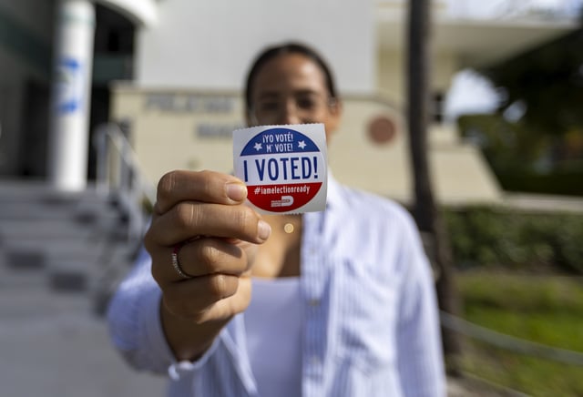 Belkis Gonzalez poses with a &#34;I Voted!&#34; sticker after her casting her vote during the General Election in Miami-Dade County at the Pelican Harbor Marina on Tuesday, Nov. 5, 2024, in Miami.