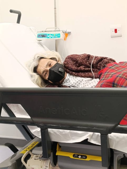 Laila Soueif lying on her hospital bed in a face mask