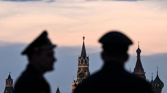 Russian servicemen stand with the Kremlin's Spasskaya tower and Saint Basil's cathedral before the Victory Day military parade rehearsal in central Moscow, on April 27, 2023. - Russia will celebrate the 78h anniversary of the 1945 victory over Nazi Germany on May 9. (Photo by Kirill KUDRYAVTSEV / AFP) (Photo by KIRILL KUDRYAVTSEV/AFP via Getty Images)