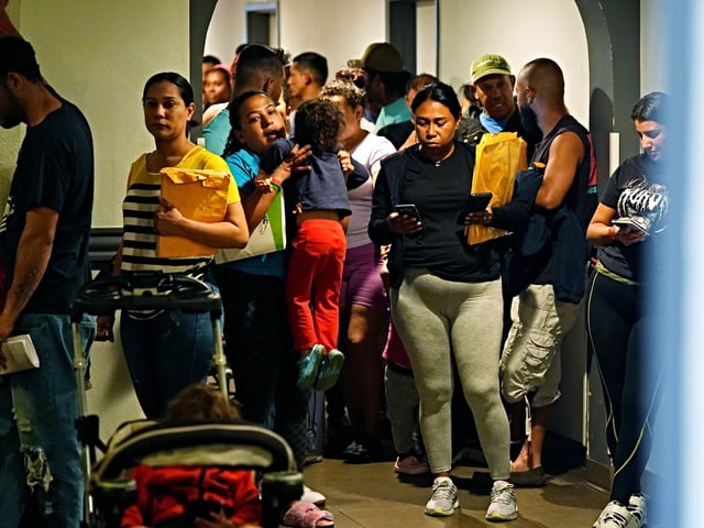People queue up to attend an orientation session for recent immigrants, Monday, May 20, 2024, in Denver. (AP Photo/David Zalubowski)