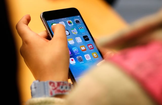 FILE - A child holds an iPhone at an Apple store on Sept. 25, 2015 in Chicago. (AP Photo/Kiichiro Sato, File)