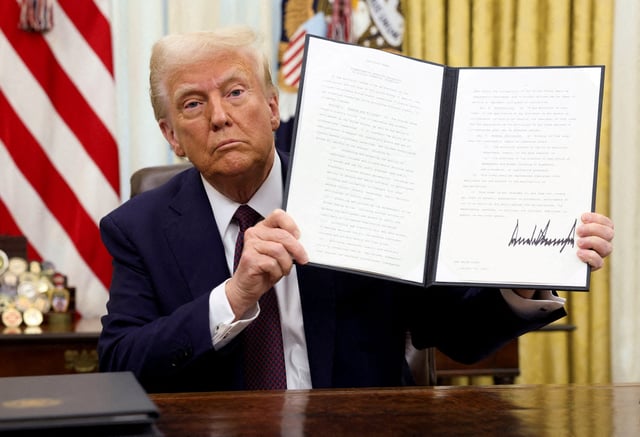 President Donald Trump holds a signed executive order on cryptocurrencies, in the Oval Office of the White House, in Washington, Jan. 23, 2025.