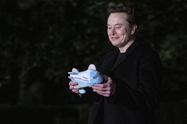 SpaceX CEO Elon Musk holds a stuffed Air Force One toy.