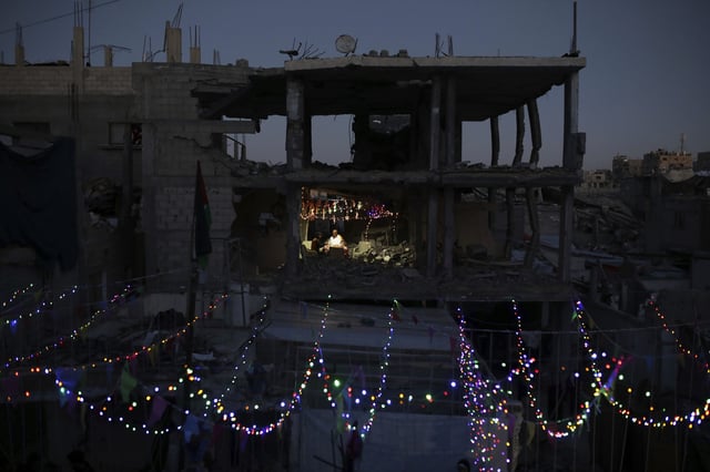 Palestinians hang decorations next to their destroyed homes in preparation for the holy month of Ramadan in Khan Younis, southern Gaza Strip, Friday, Feb. 28, 2025. (AP Photo/Jehad Alshrafi)