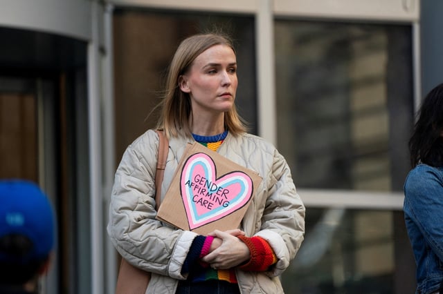 Melissa Filion holds a pro-tran sign after a hearing in the multi-state lawsuit over President Trump's order ending all federal funding or support for healthcare that aids gender transitions for people younger than 19, outside a courthouse in Seattle, Washington, U.S., February 28, 2025.