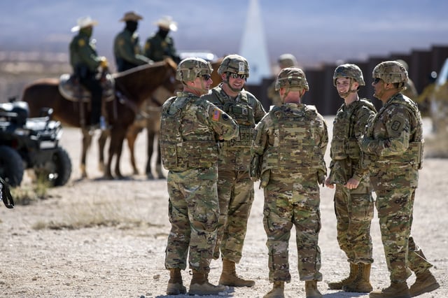 Army soldiers chat while waiting the arrival of Defense Secretary Pete Hegseth to the US-Mexico border in Sunland Park, N.M., Monday, Feb. 3, 2025. (AP Photo/Andres Leighton)