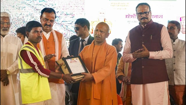Chief minister Yogi Adityanath felicitating a municipal worker after the conclusion of Maha Kumbh in Prayagraj. (PTI)