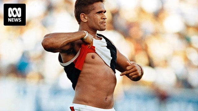 An Indigenous AFL player lifts his shirt and points to the colour of his skin in response to racial vilification by the crowd.