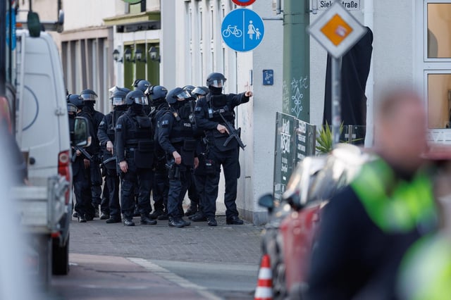 Einsatzkräfte der Polizei sichern eine Straße vor dem Landgericht