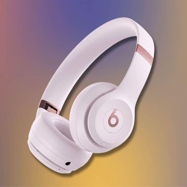 pink beats solo 4 headphones against a purple, yellow, and orange gradient background
