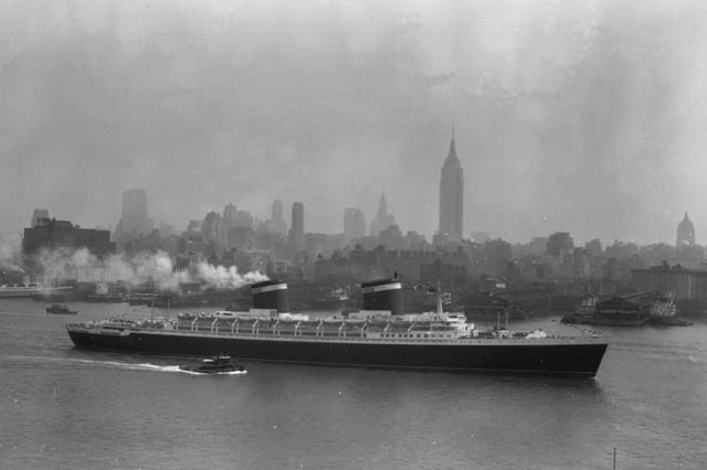 FILE - The SS United States travels along the Hudson River as it begins its first voyage to Europe from New York, July 3, 1952, with the view of the Midtown Manhattan skyline including the Empire State Building at center right. (AP Photo/Jack Harris, File)