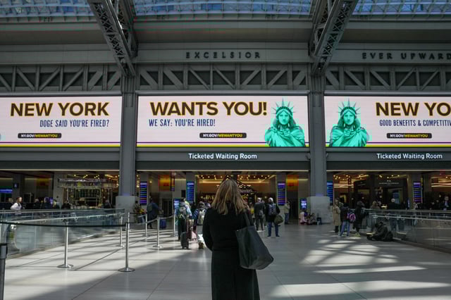 People walk past digital billboards at the Moynihan Train Hall displaying a new initiative from New York Governor Kathy Hochul titled 'New York Wants You', a program designed to recruit and employ displaced federal workers across New York State, in New York, U.S., March 3, 2025. REUTERS/David Dee Delgado