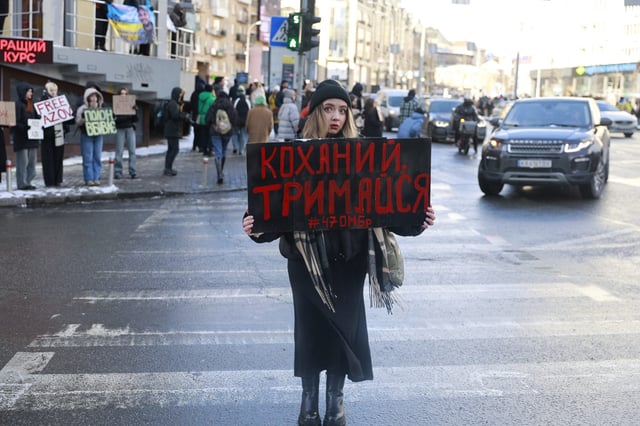 Alina Potapova holds a placard at a demonstration in Kyiv. The sign reads “Hold on, my love”. Her fiancee went missing in July 2023, and was later confirmed to be in Russian captivity. Alina has not received any letters from him